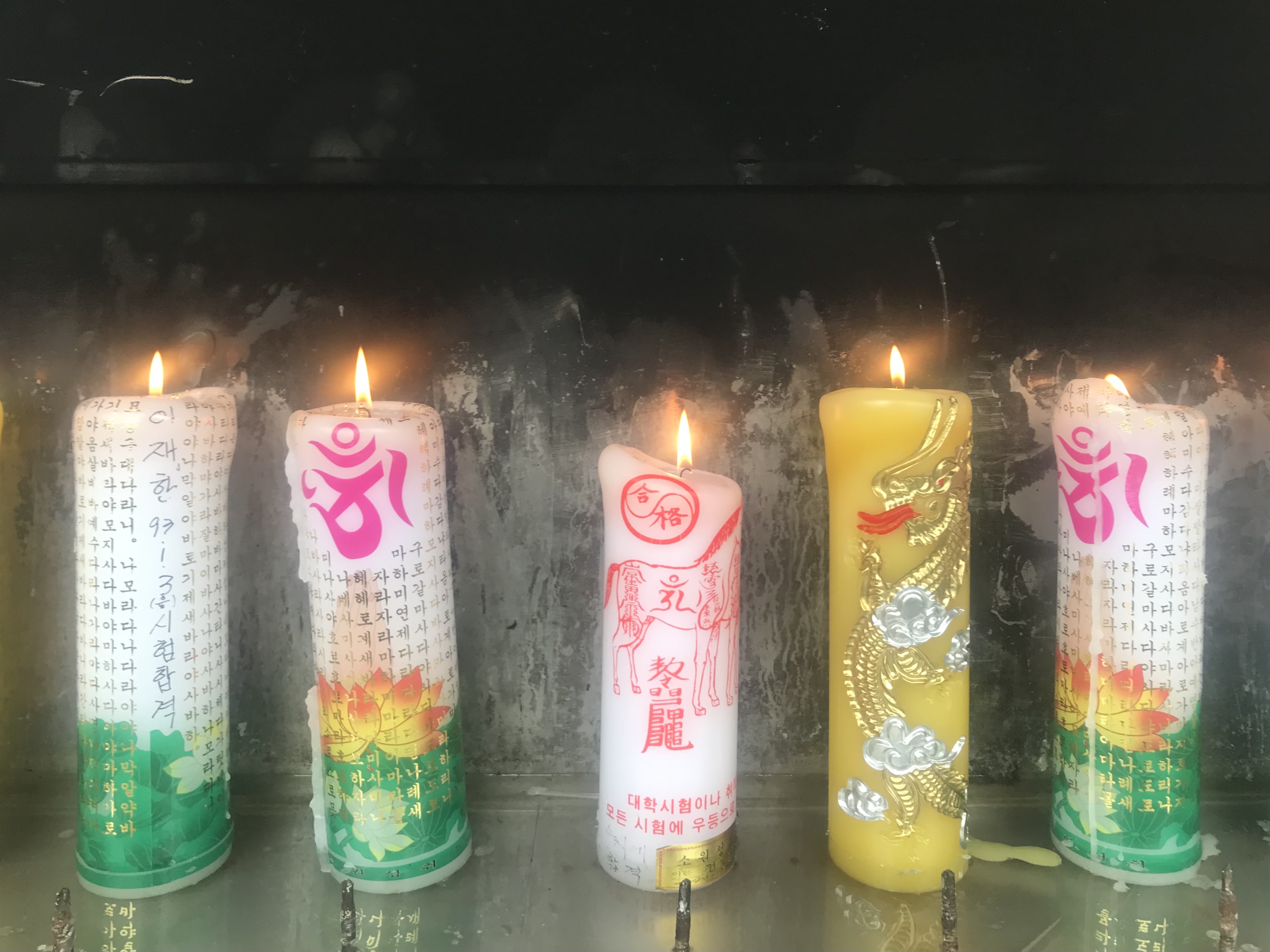 four lit candles at a temple